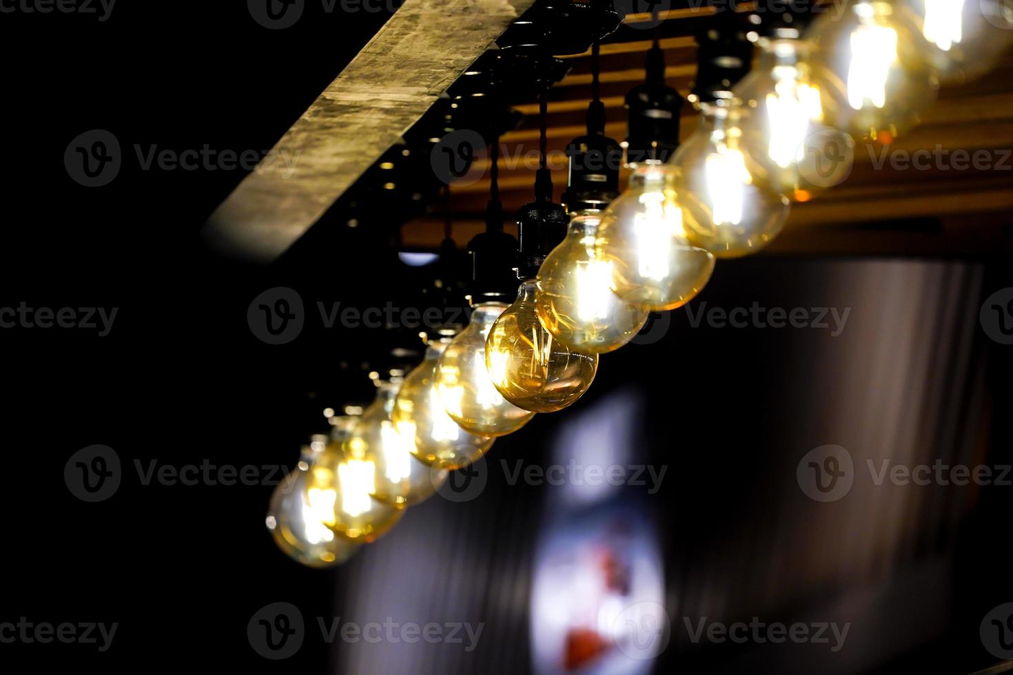 Tungsten circle lamp light on the row, stick on the wood kiosk ceiling. photo