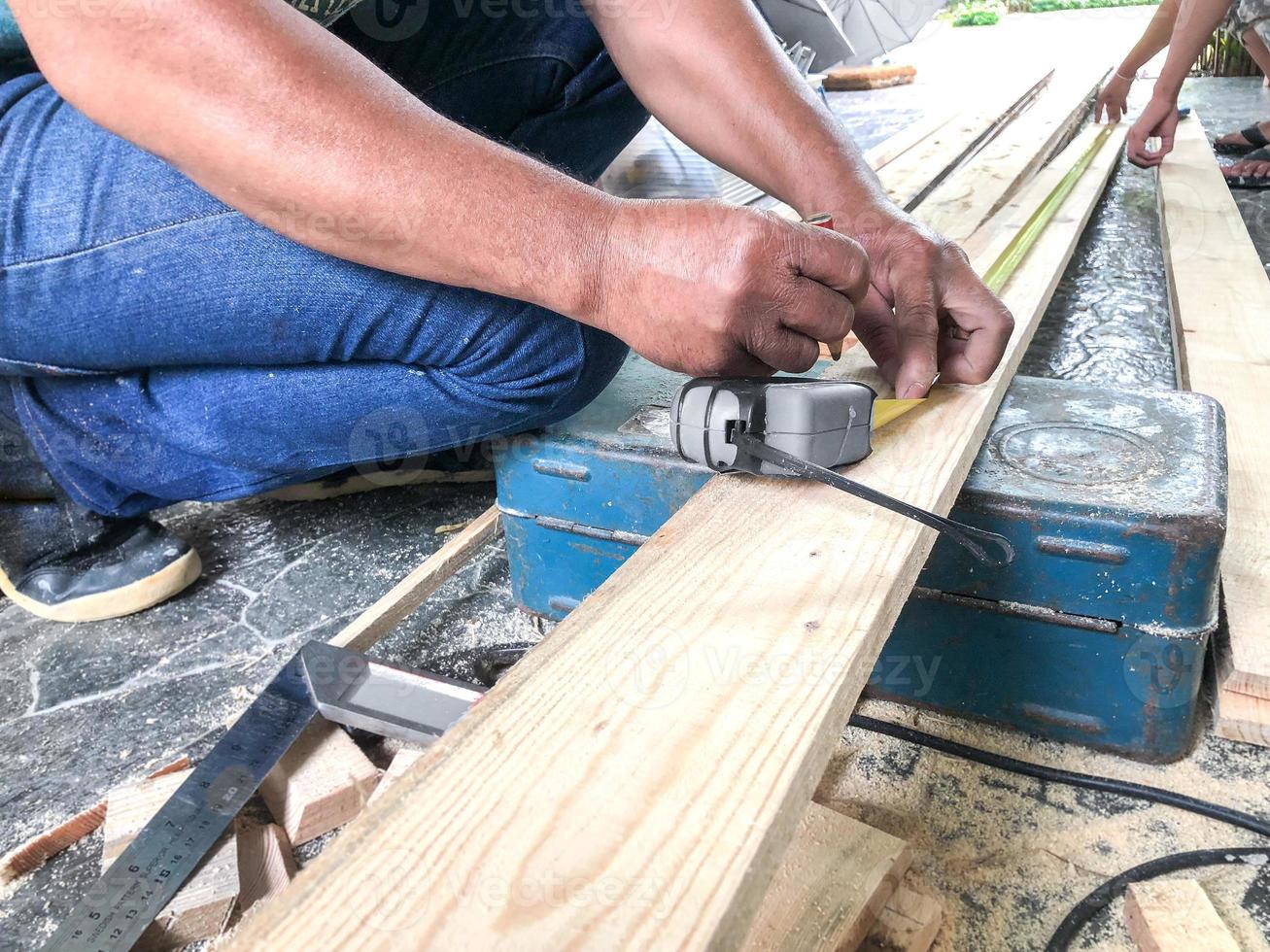 Carpenter was sawing the wood. photo