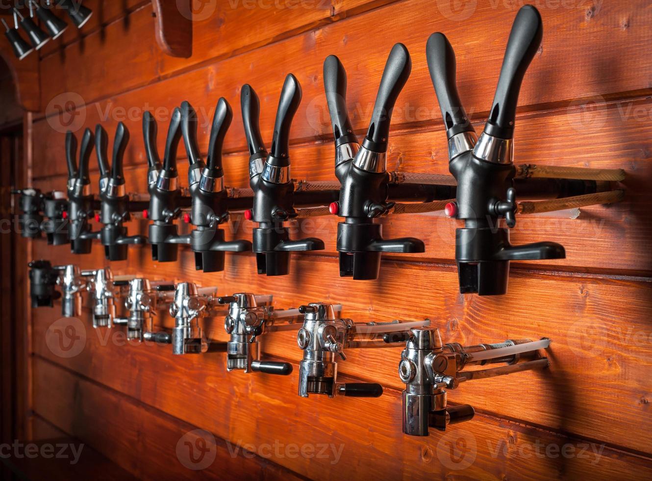 Beer taps for draught drinks are built into wooden boards photo