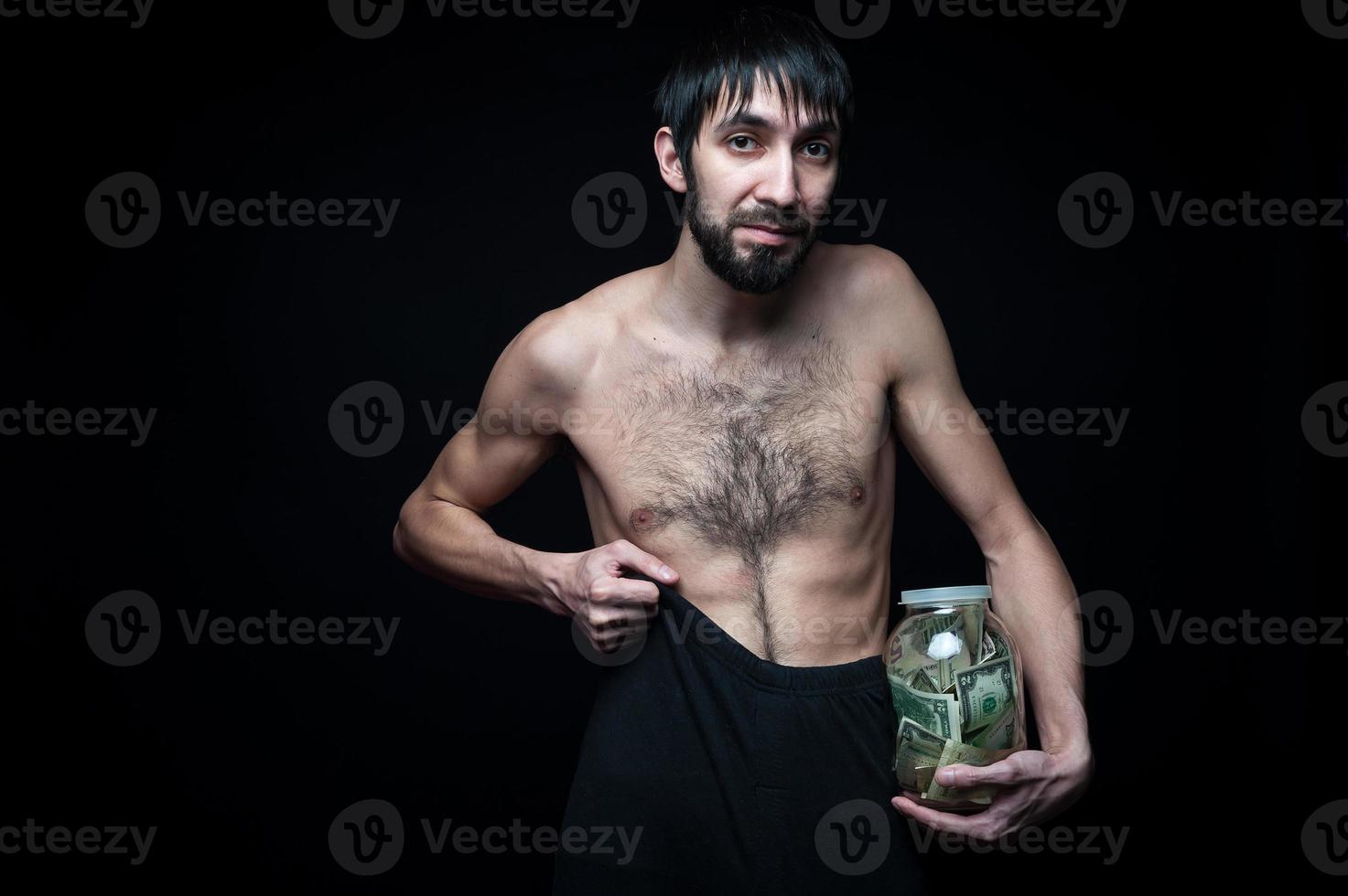 Young man with money bottle on black background photo