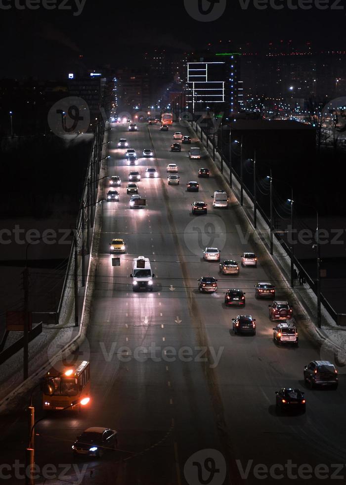 los senderos de luz del coche en la carretera en la ciudad moderna de noche foto