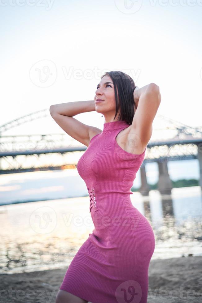 Girl walking on the beach, against the sunset. photo