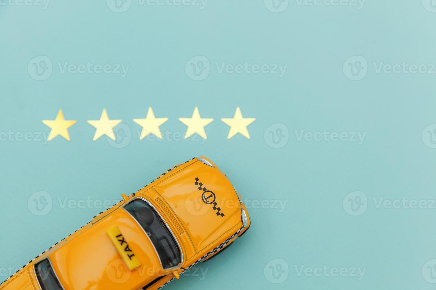 Yellow toy car Taxi Cab and 5 stars rating isolated on blue background. Smartphone application of taxi service for online searching calling and booking cab concept. Taxi symbol. Copy space. photo