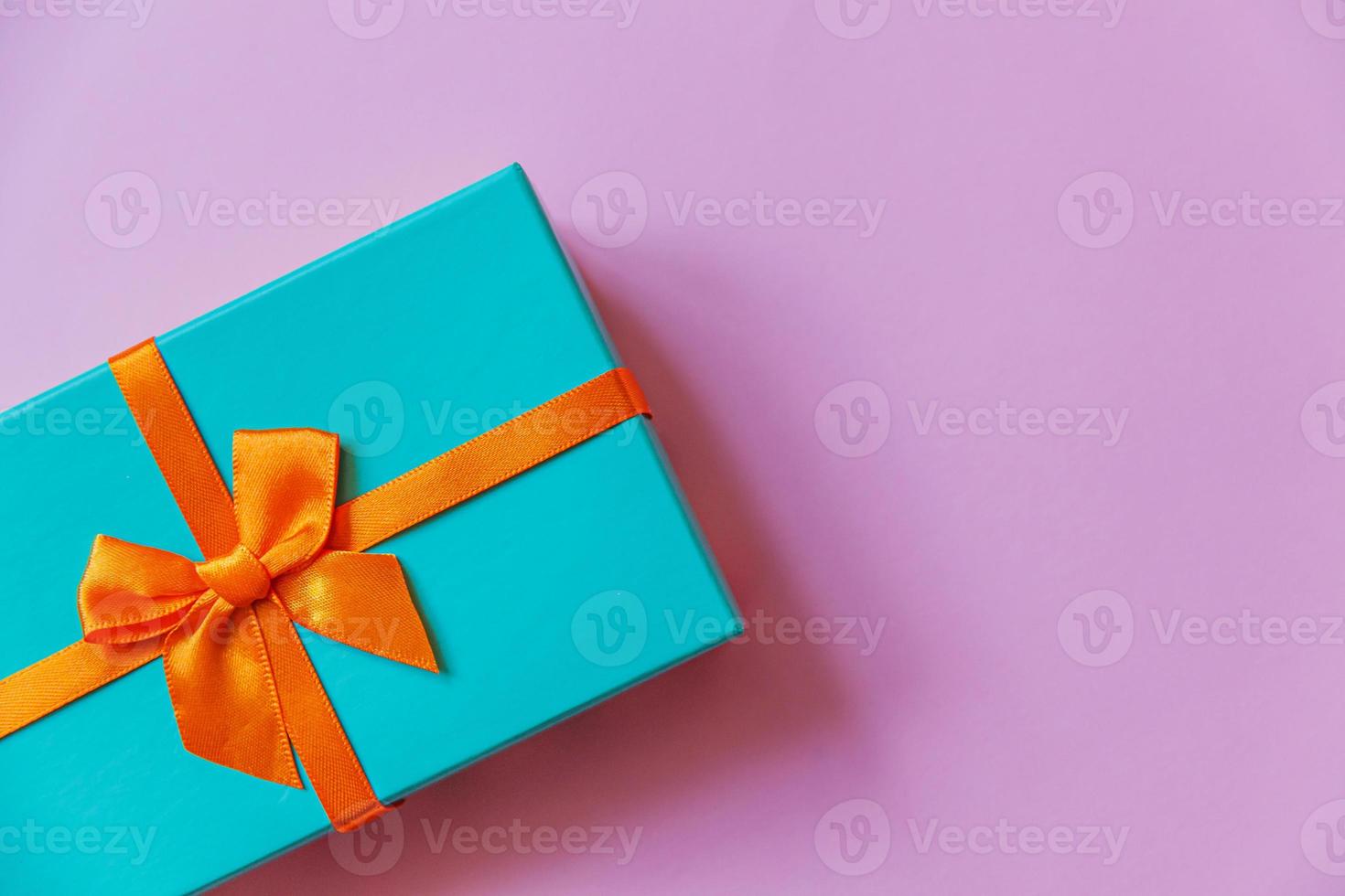 Christmas New Year birthday valentine celebration present romantic concept. Simply minimal design blue gift box isolated on violet purple colorful background. Flat lay top view, copy space photo