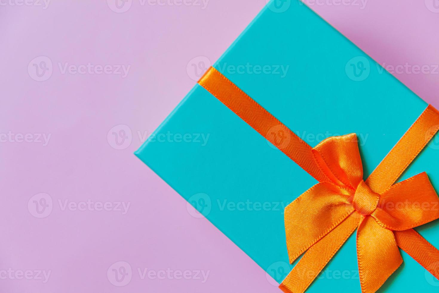 Christmas New Year birthday valentine celebration present romantic concept. Simply minimal design blue gift box isolated on violet purple colorful background. Flat lay top view, copy space photo