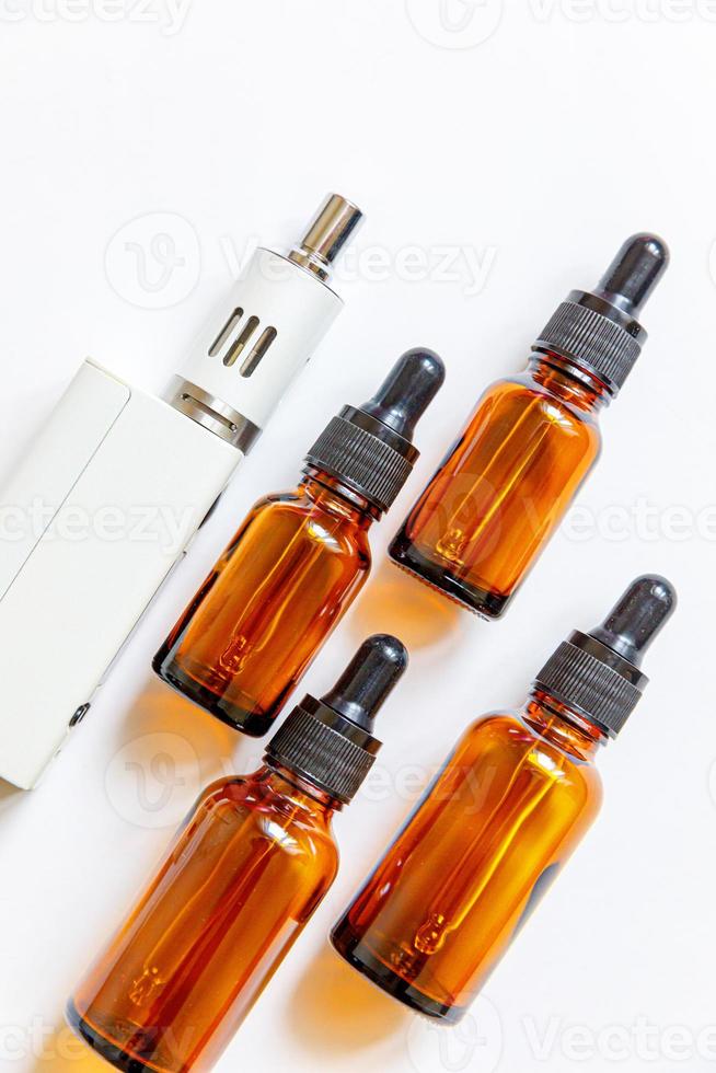 Vaping device e-cigarette electronic cigarette and liquid bottles isolated on white background. Vape device for alternative smoking. Vaping shop concept. Gadget for vaper. Vaping accessories. photo