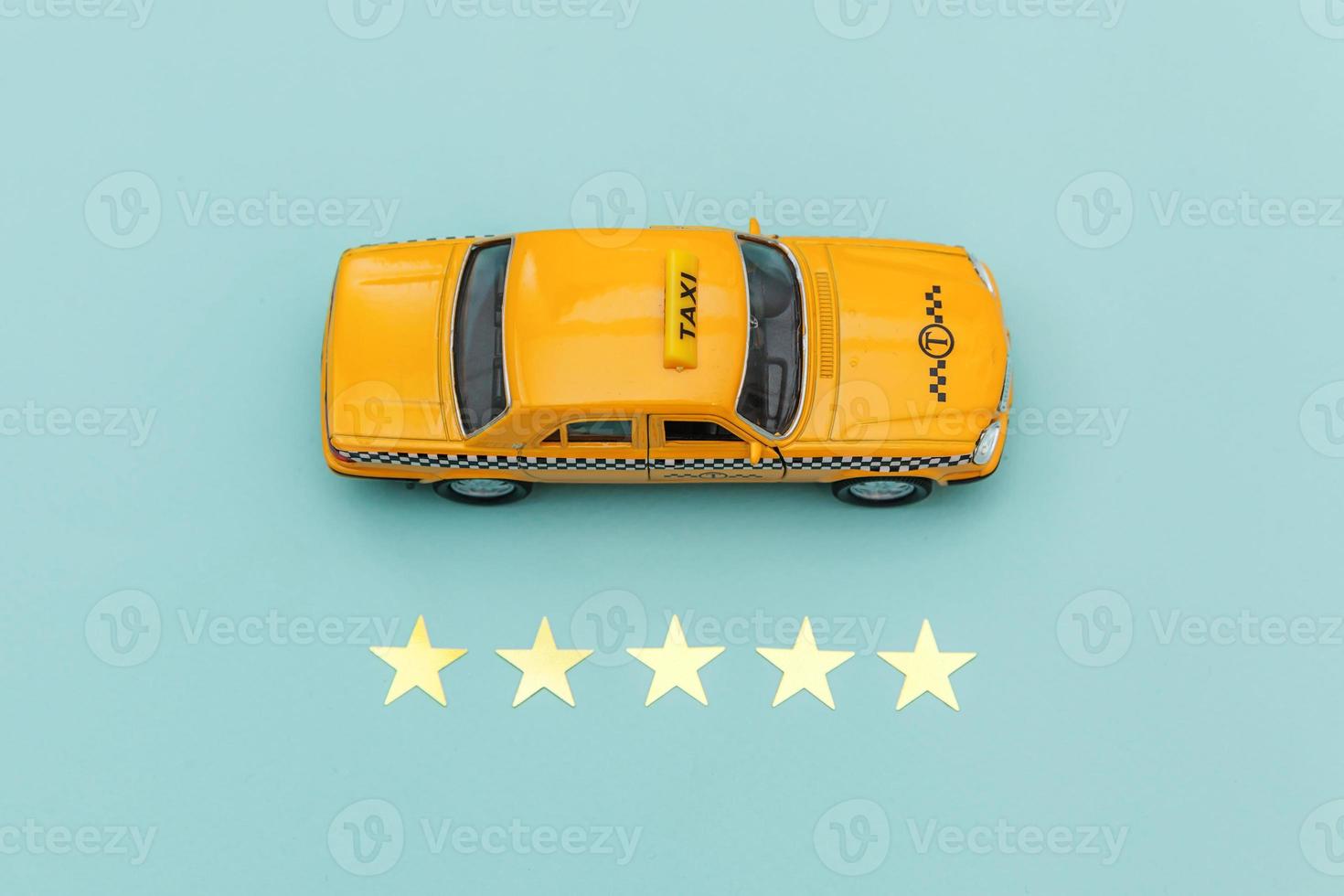 Yellow toy car Taxi Cab and 5 stars rating isolated on blue background. Smartphone application of taxi service for online searching calling and booking cab concept. Taxi symbol. Copy space. photo