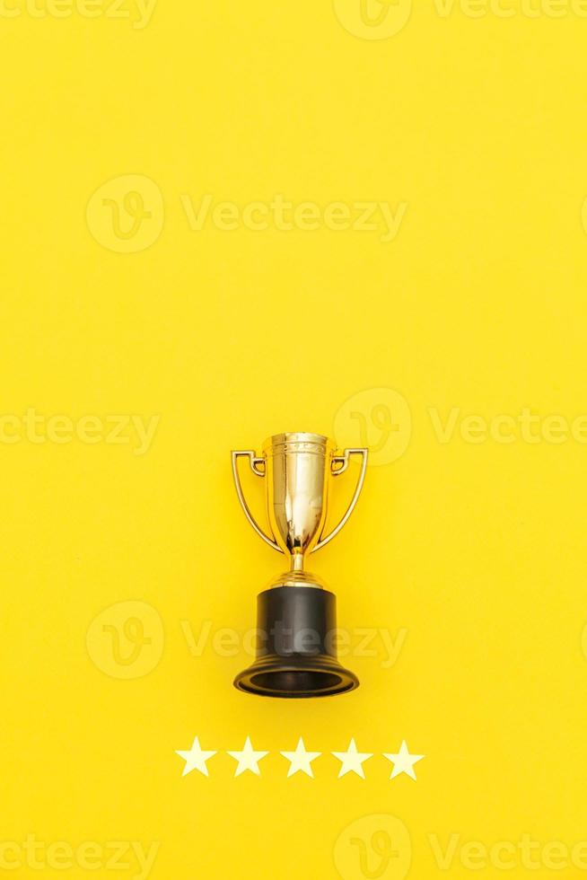 Simply flat lay design winner or champion gold trophy cup and 5 stars rating isolated on pink pastel background. Victory first place of competition. Winning or success concept. Top view copy space. photo