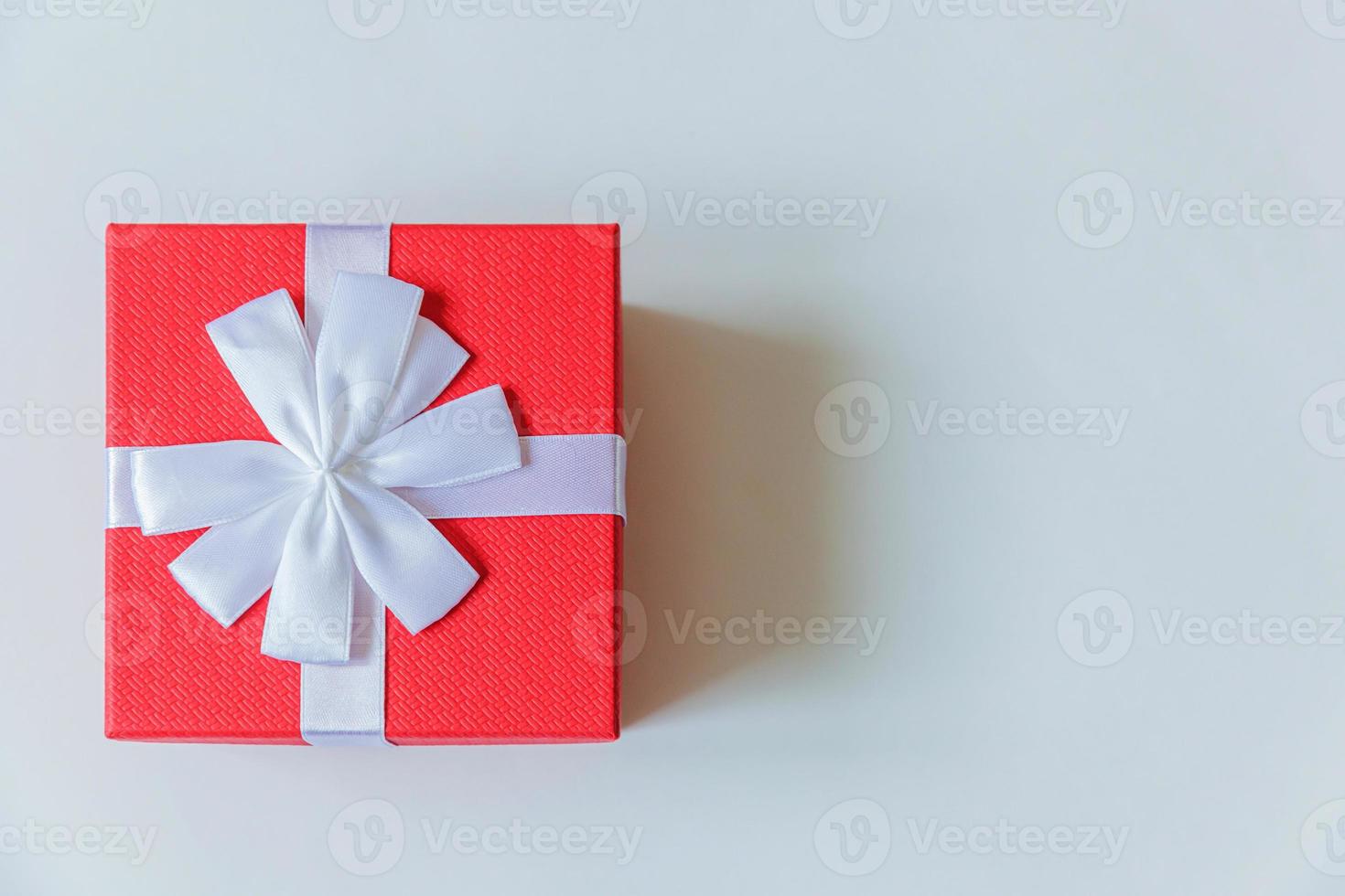 Christmas New Year birthday valentine celebration present romantic concept. Simply minimal design red gift box isolated on white background. Flat lay top view copy space. photo