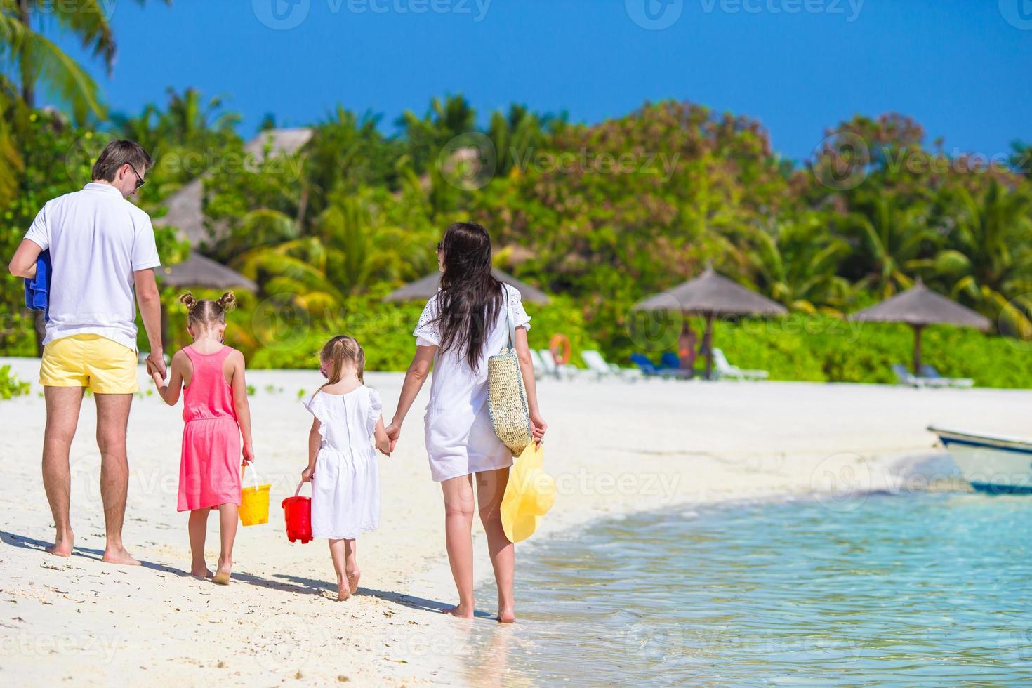 Happy family on white beach during summer vacation photo