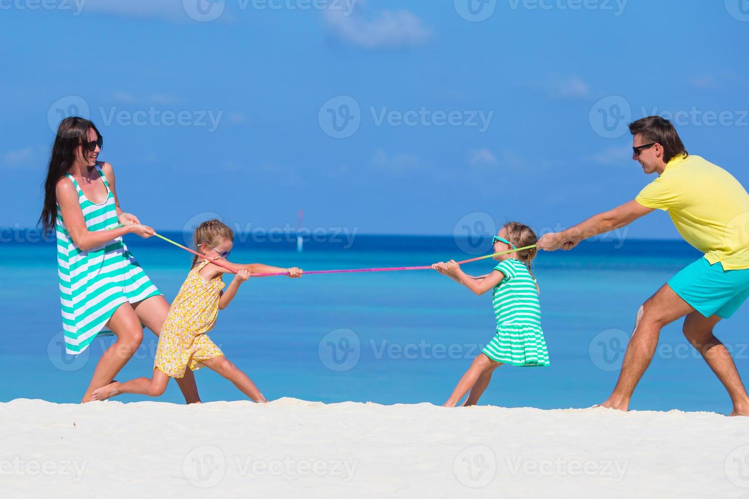 Happy family playing together on white beach photo