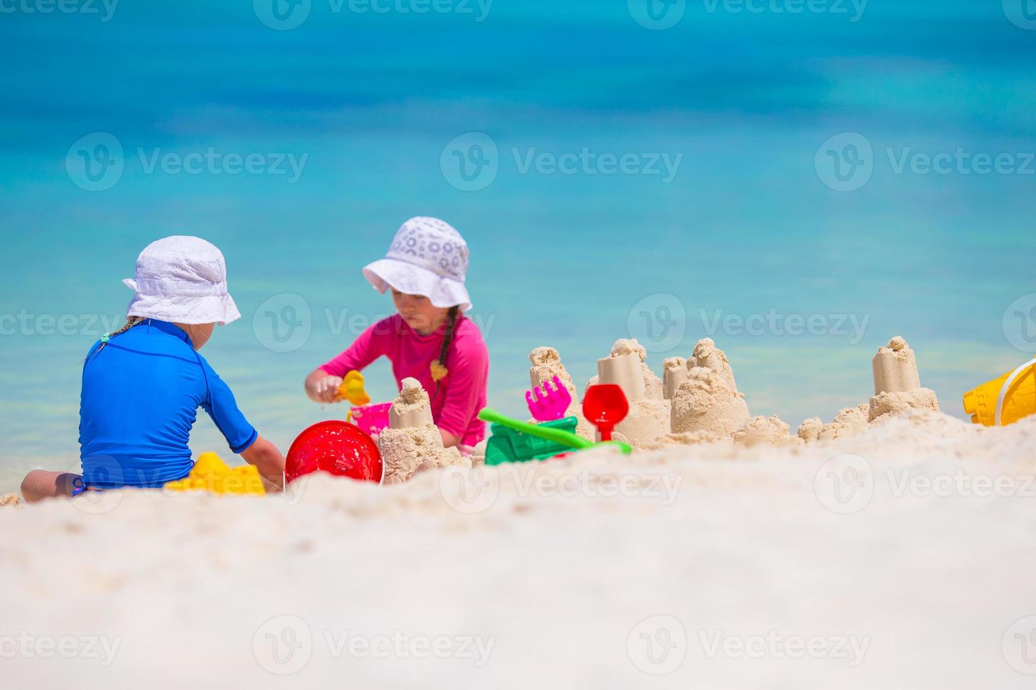 niñas jugando con juguetes de playa durante las vacaciones tropicales foto