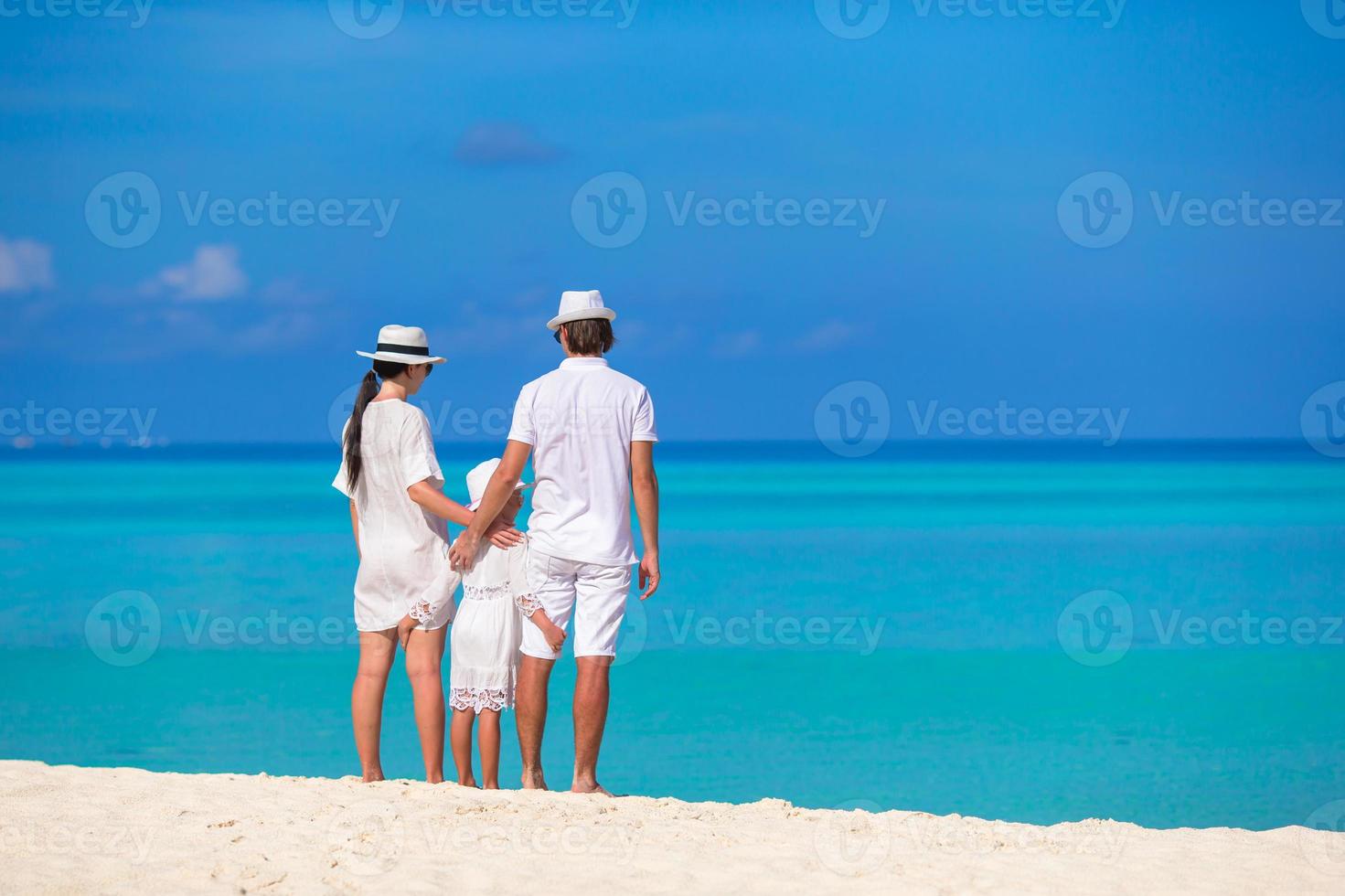 Young family on white beach during summer vacation photo