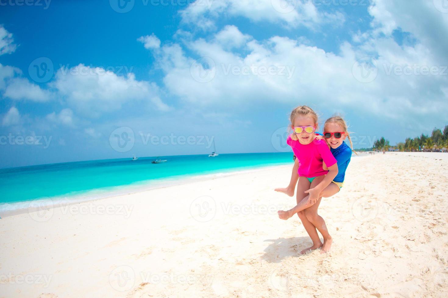 Kids having fun at tropical beach during summer vacation playing together at shallow water photo