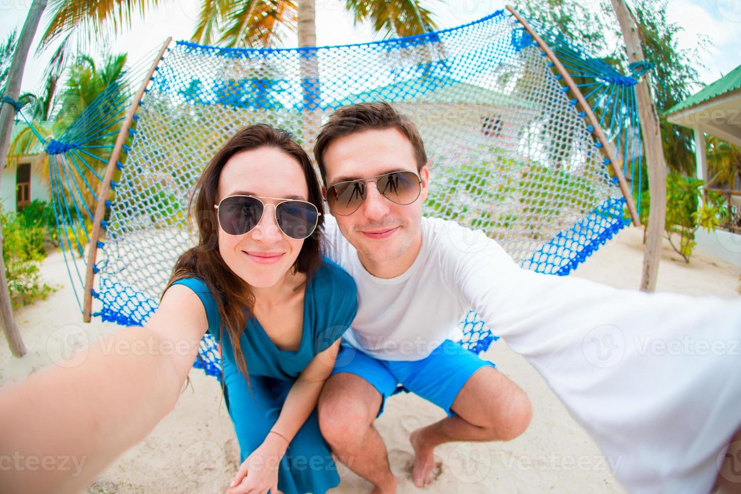 Happy couple making selfie relaxing in hammock photo