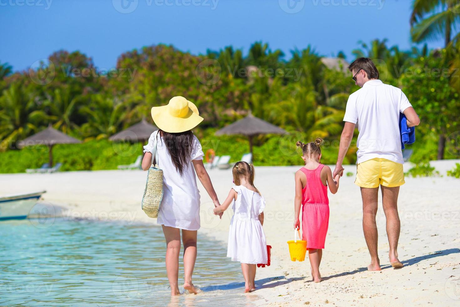 Young family on white beach during summer vacation photo