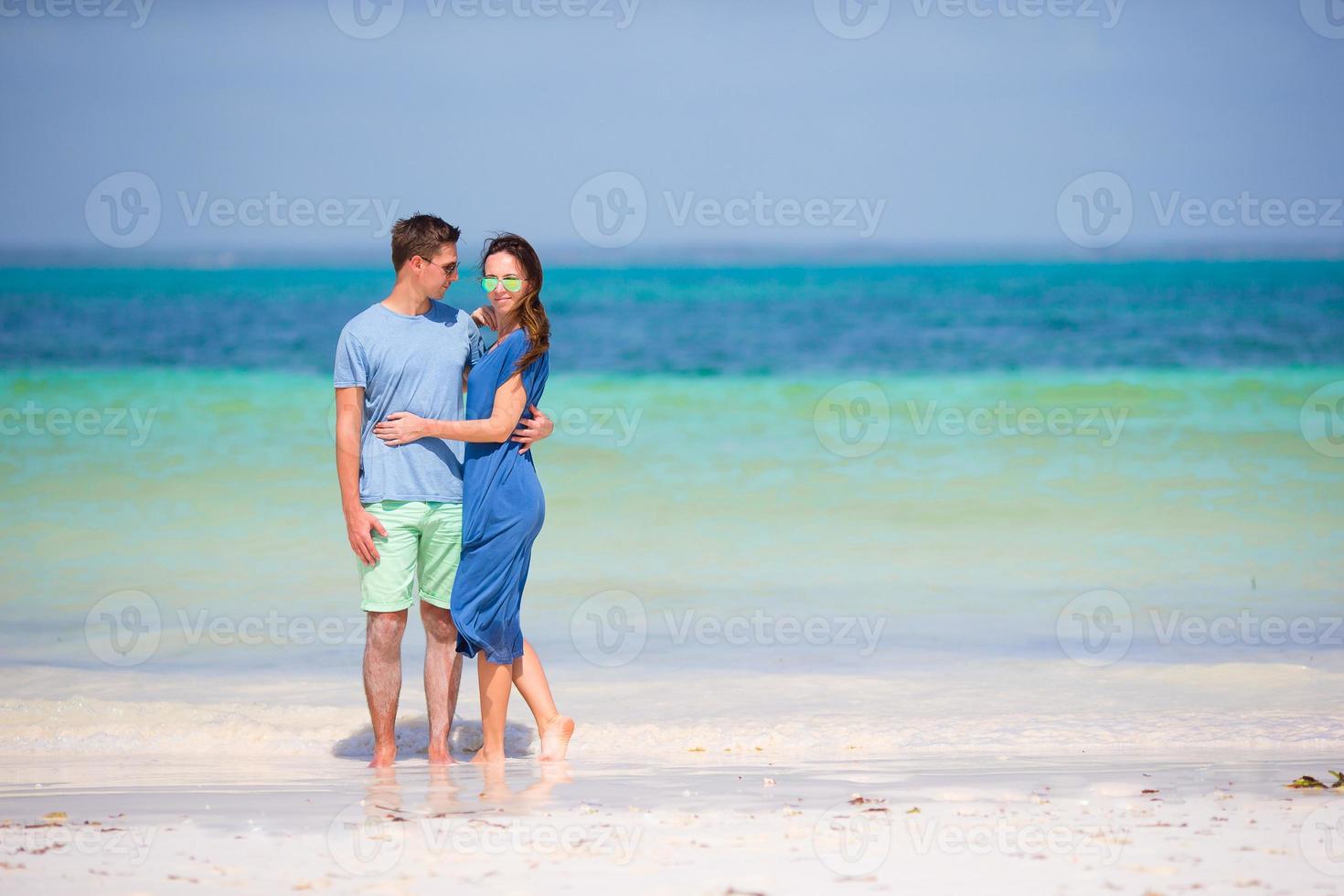 Young happy couple on white beach at summer vacation photo