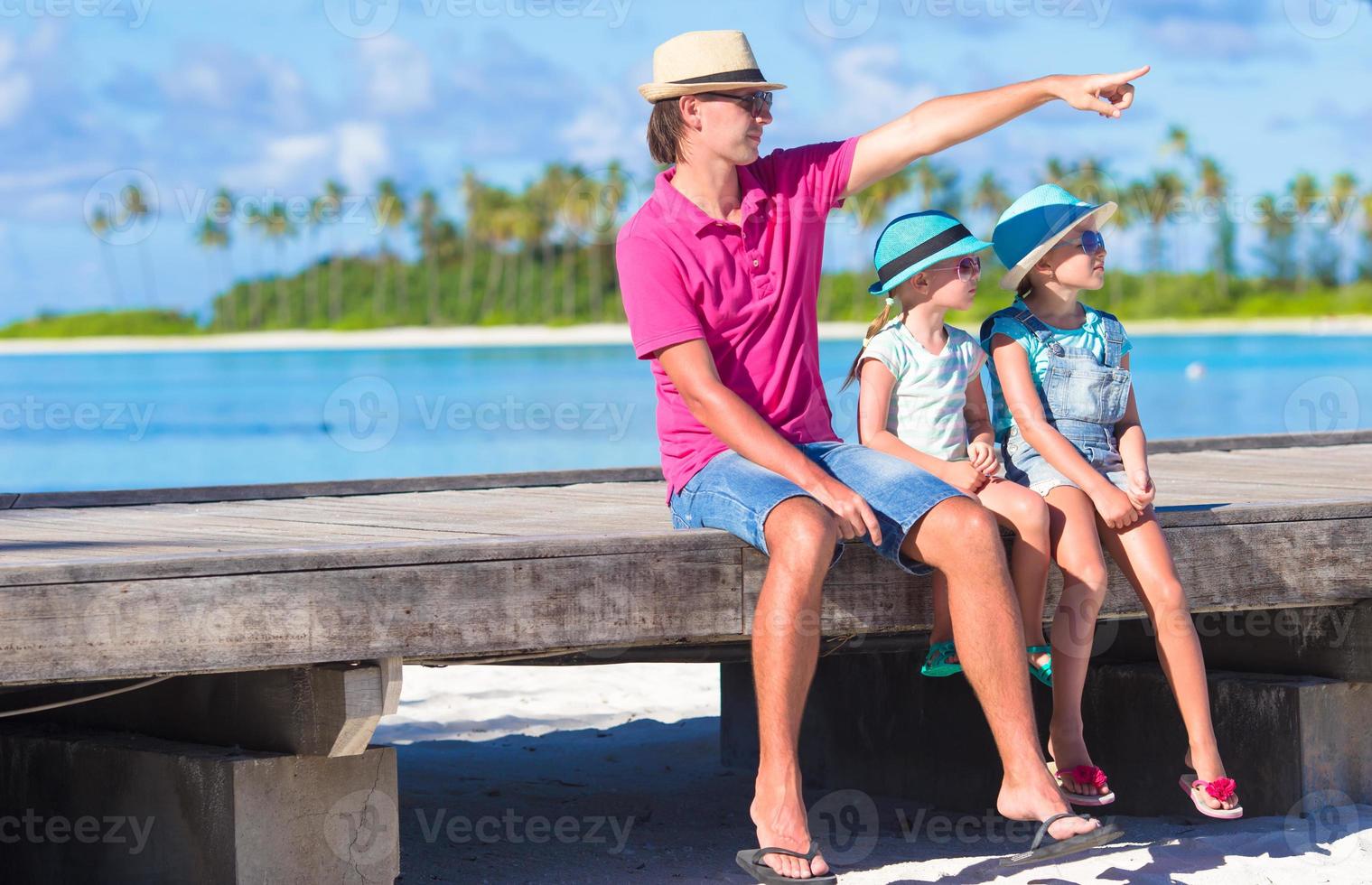 Father and little daughter on wooden jetty near water bungalow photo