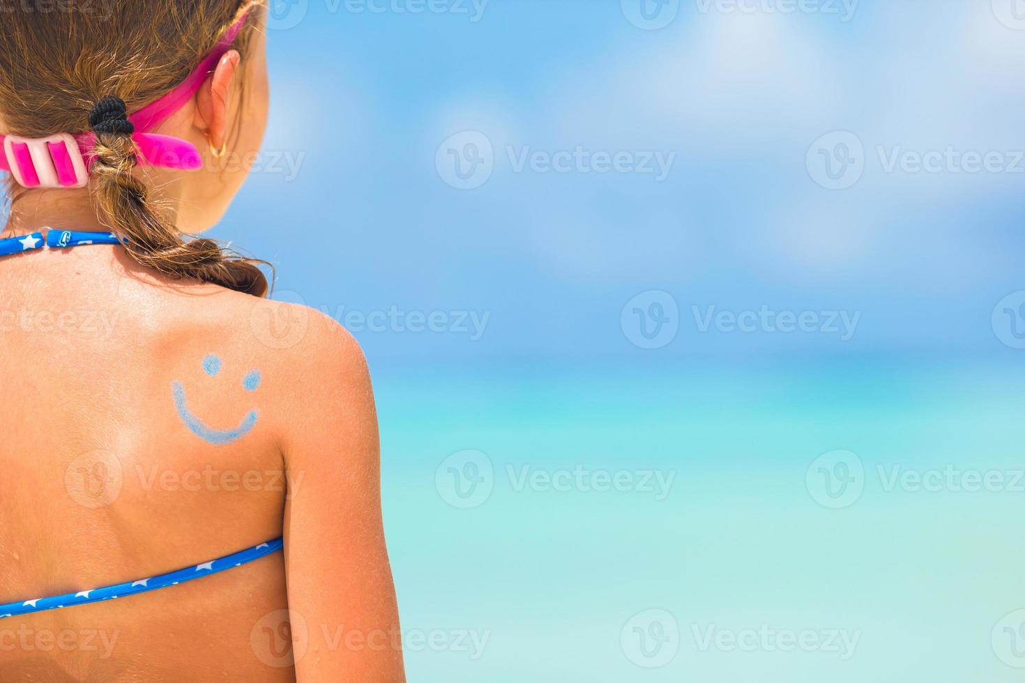 Close up smile painted by sun cream on kid shoulder photo