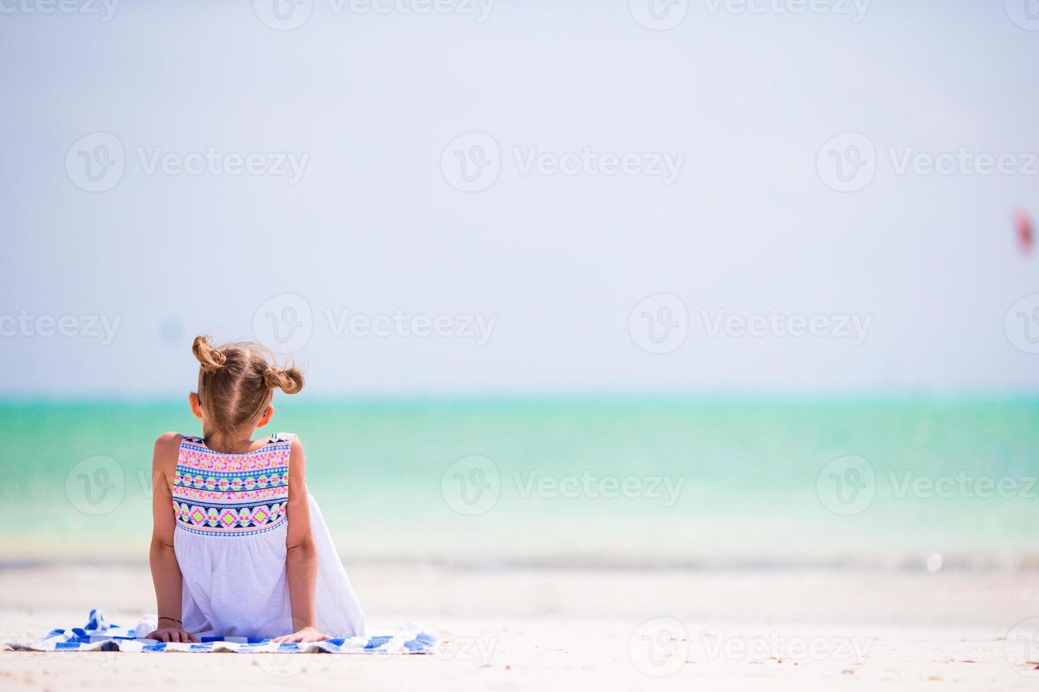 Cute little girl at beach during summer vacation photo