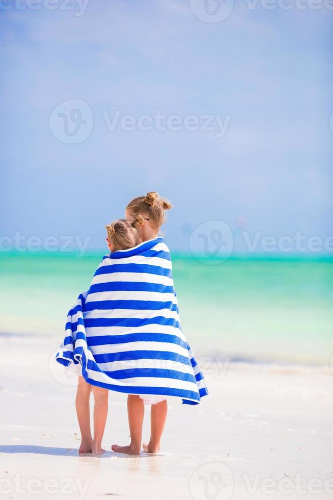 Adorable little girls wrapped in towel at tropical beach photo