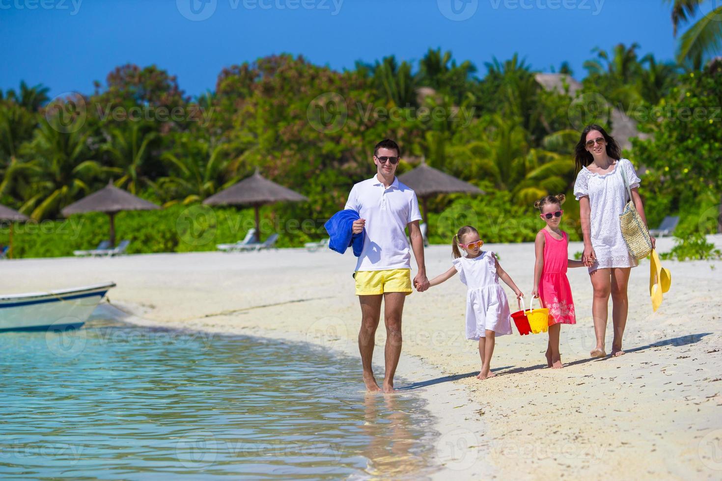 Happy family during summer vacation on white beach photo