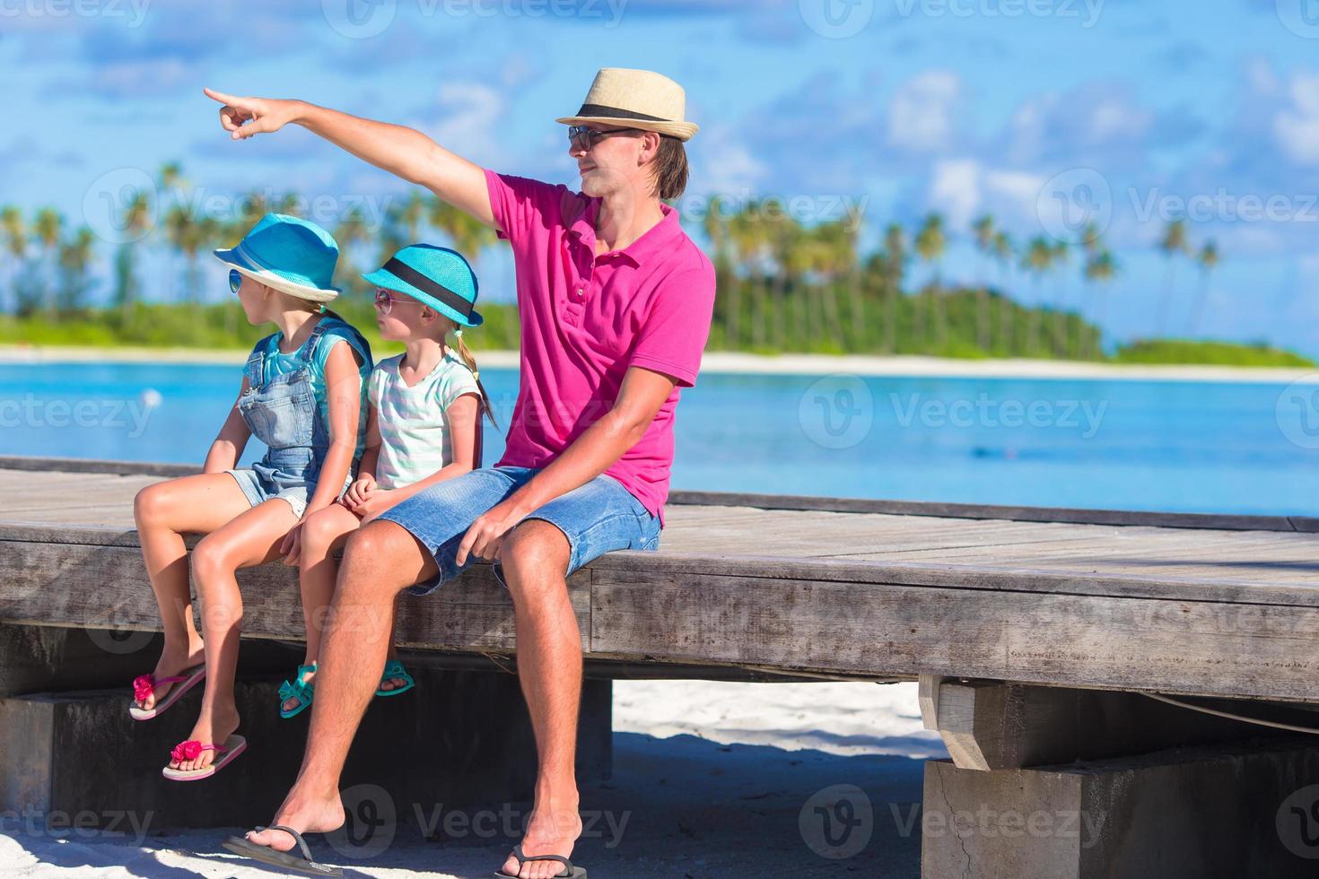 Father and little daughter on wooden jetty near water bungalow photo