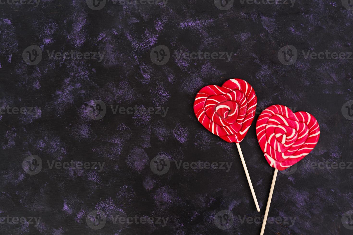 Colorful lollipops on dark background. Top view photo