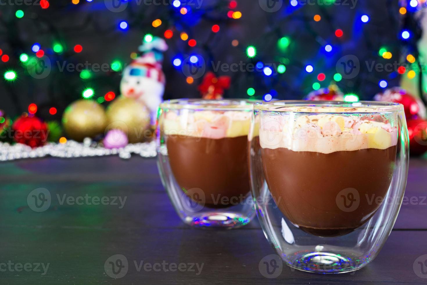 taza de chocolate caliente con malvaviscos sobre fondo de navidad foto