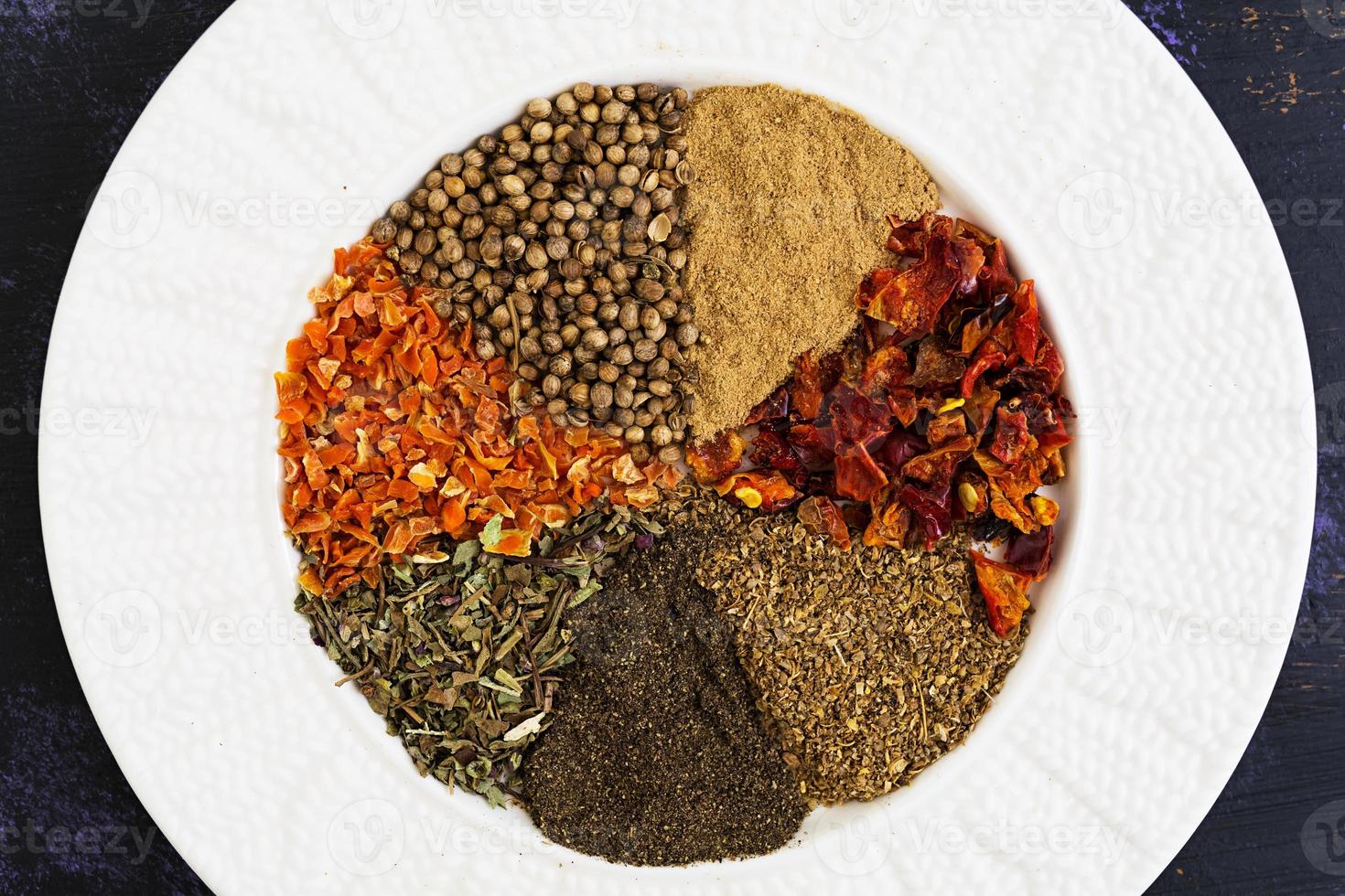 Different spices on dark background. Top view photo