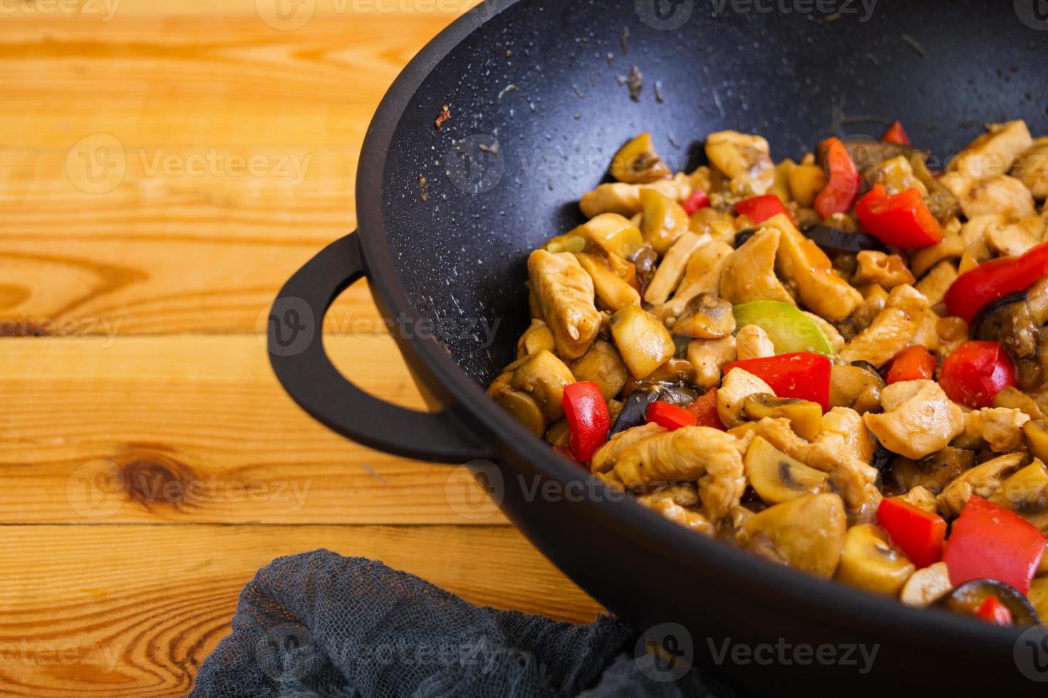 Stir fry chicken, zucchini and pepper in wok photo