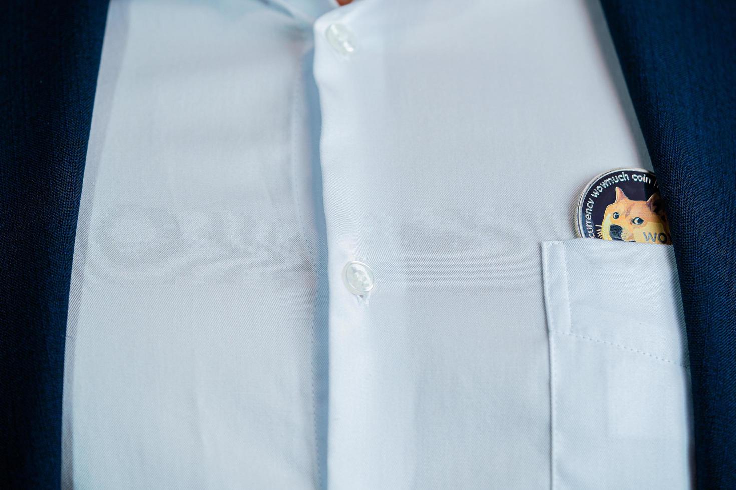 Dogecoin DOGE included with Cryptocurrency on suit bag business man wearing a blue suit. Filed and put and give to me. photo