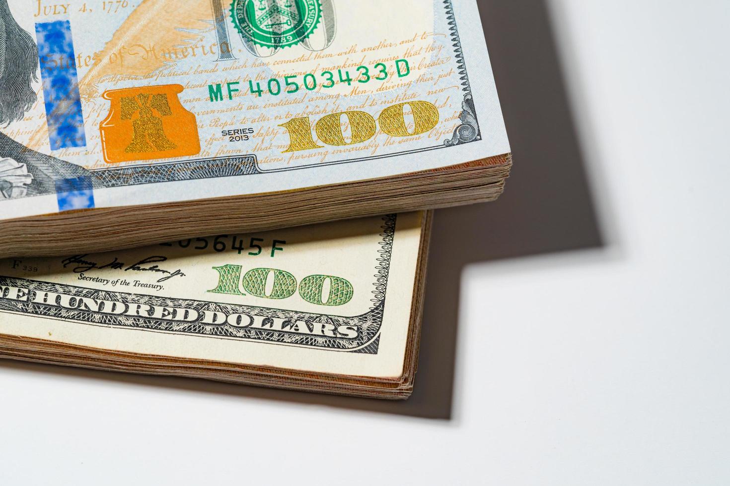 A pile of hundred Money stack US dollar USD, Pay, exchange and looking at numbers 100 for business bills investment concept Close up Macro photography isolated on white background and free space. photo