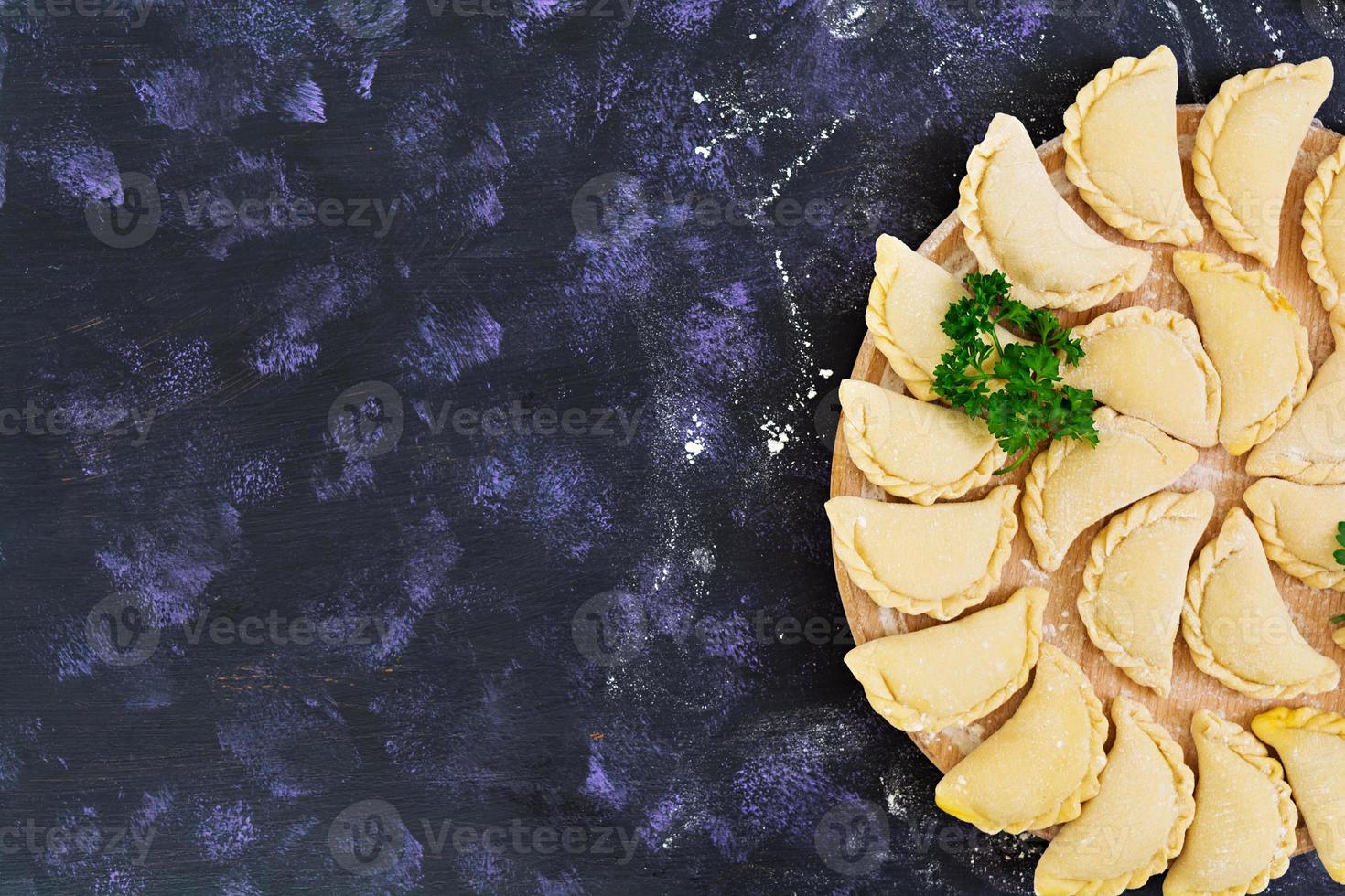 Delicious dumplings with cabbage on dark background. Top view photo