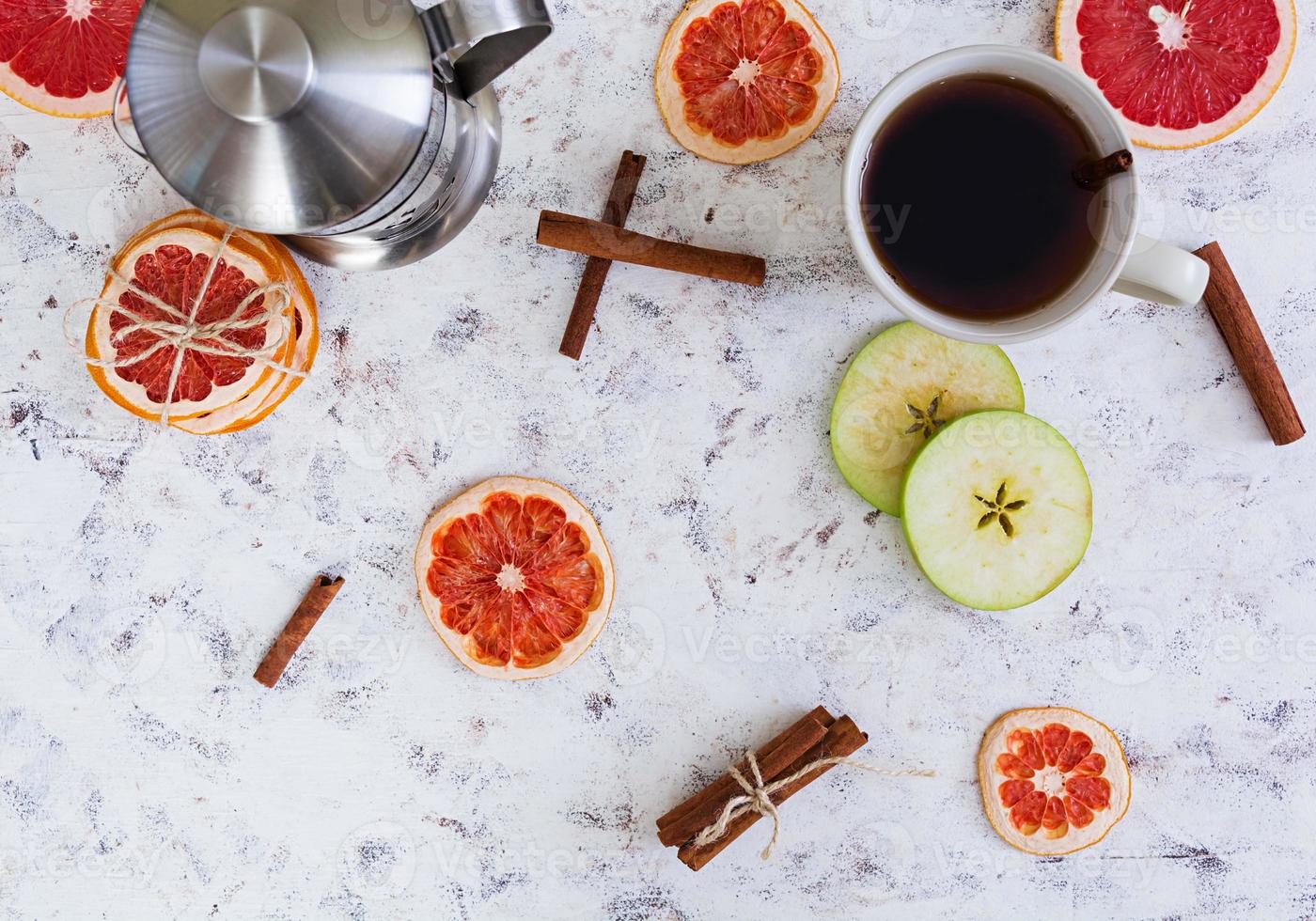 Fruit tea with apple, grapefruit and cinnamon on wooden background photo