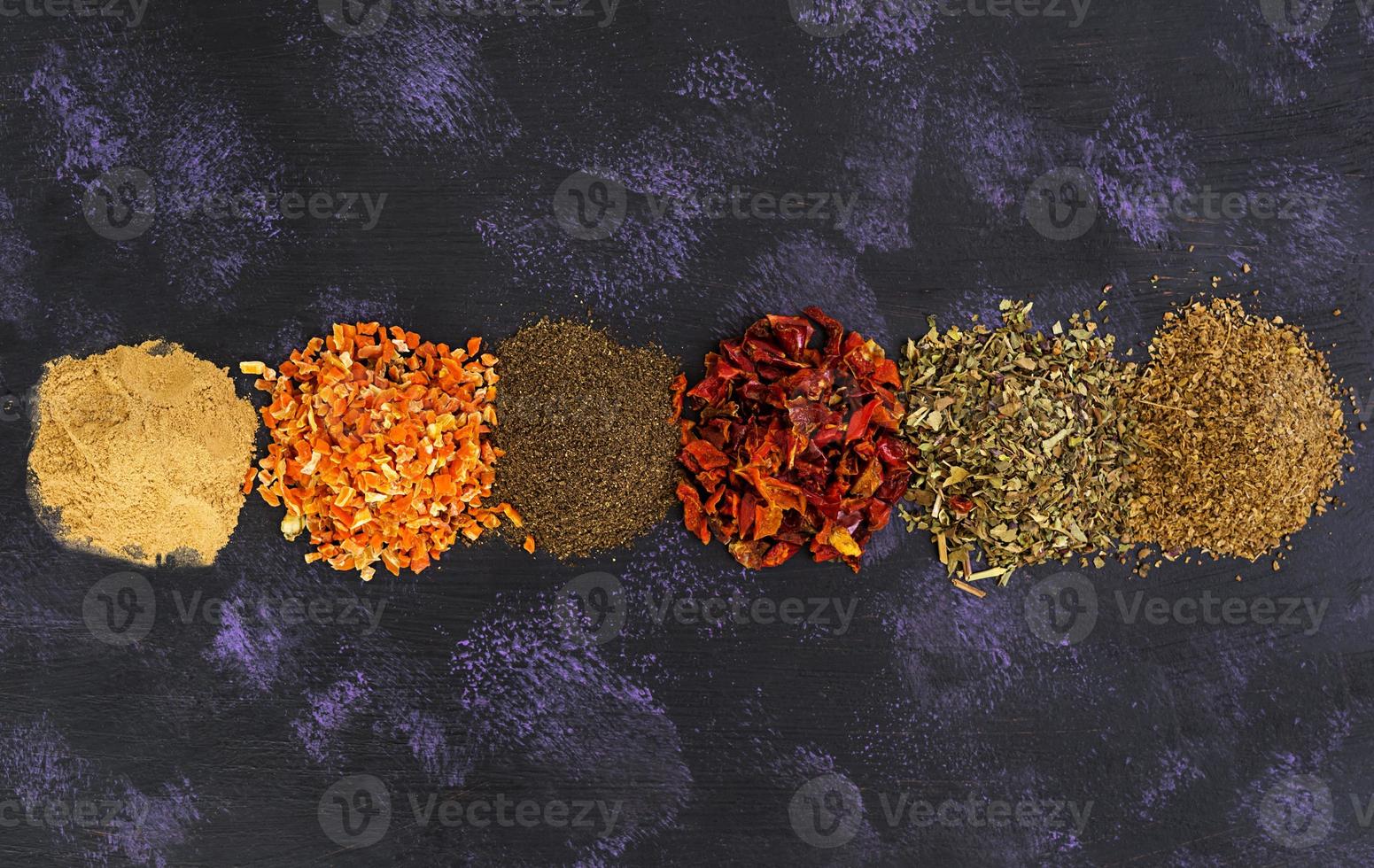 Different spices on dark background. Top view photo