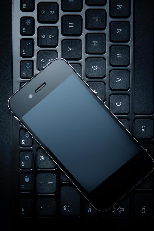Smartphone and laptop keyboard photo