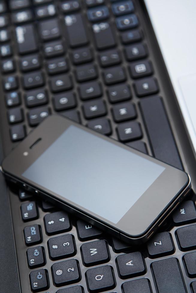 Smartphone and laptop keyboard photo