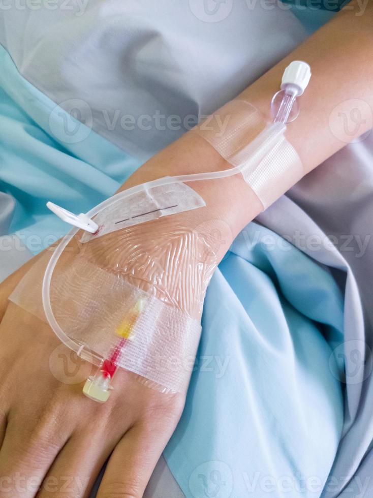 The piercing needle for giving saline solution to patients on the back of the hand. photo