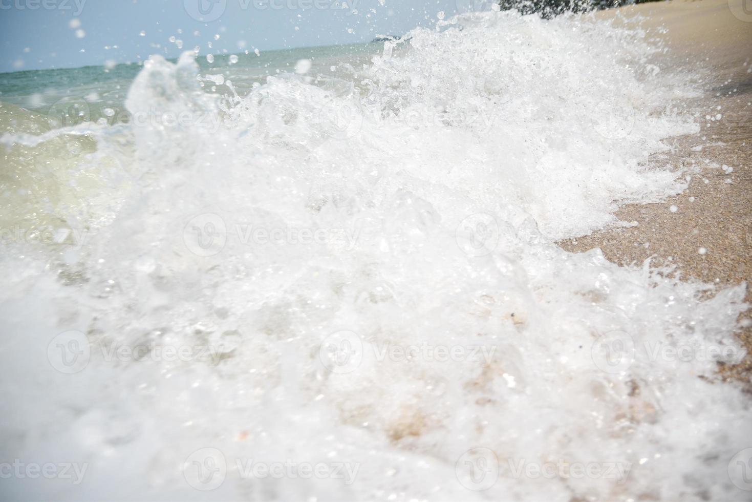 Wide angle shot of sea water hitting the beach, white sponge of the sea, summer nature background image concept. photo