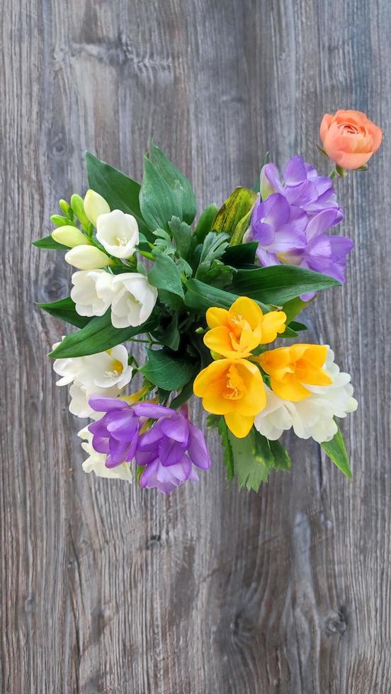 Three beautiful buttercups and hyacinths on a wooden table. Top view of the flowers. Great for presentations, decor and web design. photo