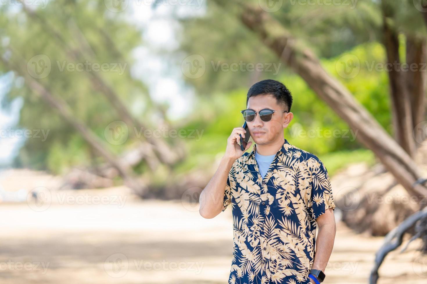 Male tourists playing mobile phones in the middle of the sea in Thailand photo