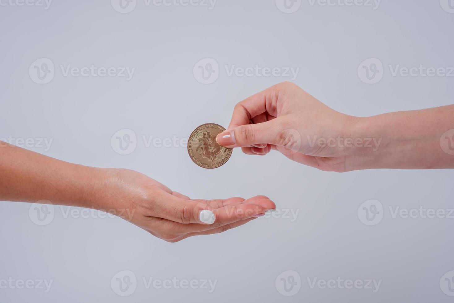 Businessman gives gold bitcoins to another woman. two hands exchanging digital currency A new world of online currency development photo