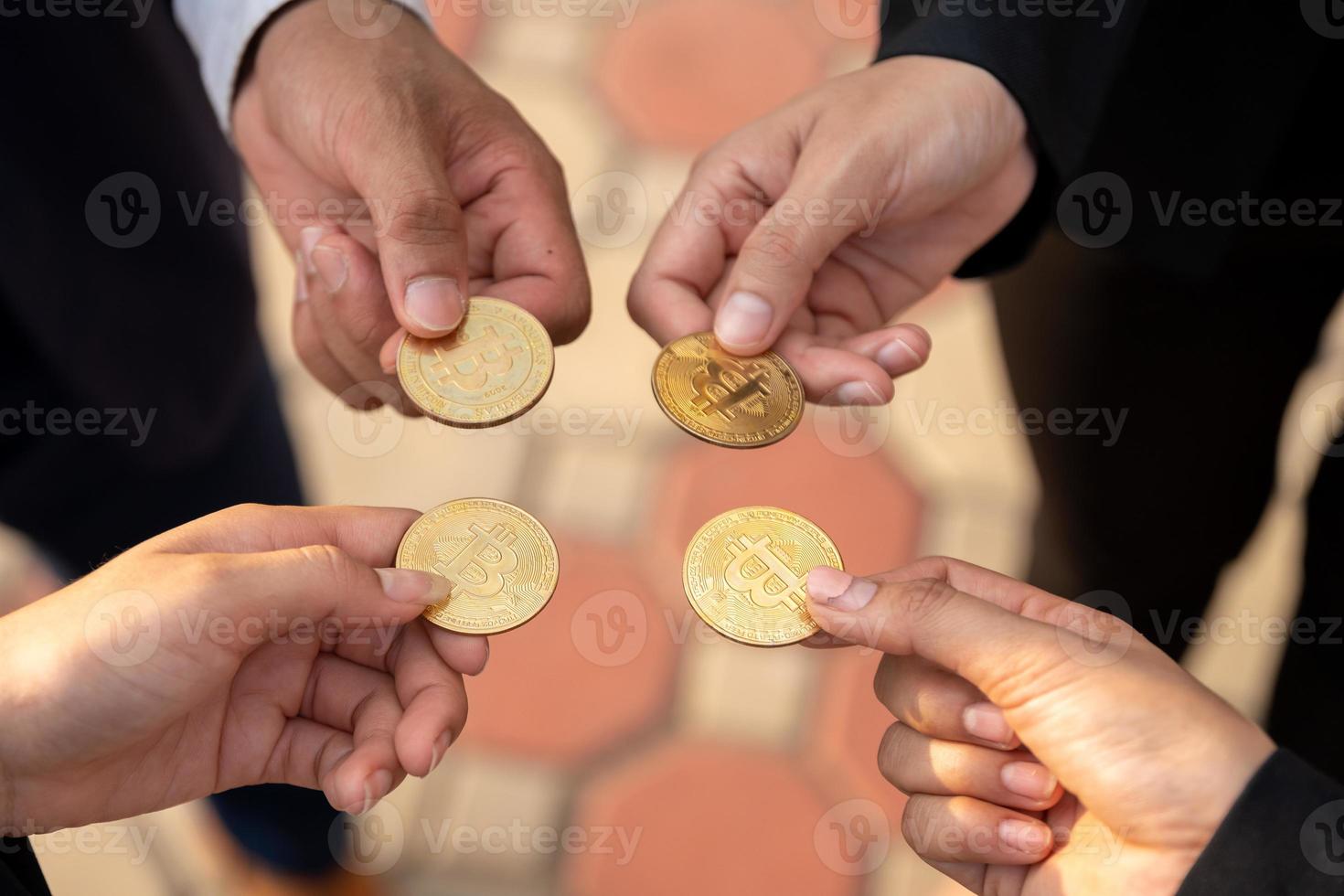 group of businesspeople with bitcoins in hand photo