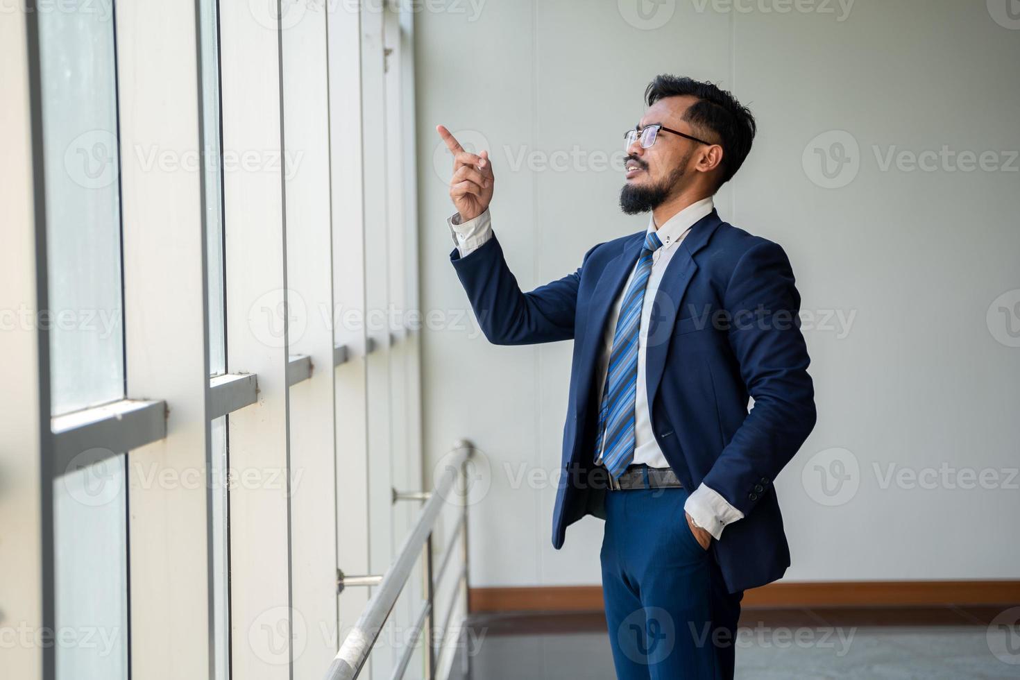 young businessman standing by the window photo