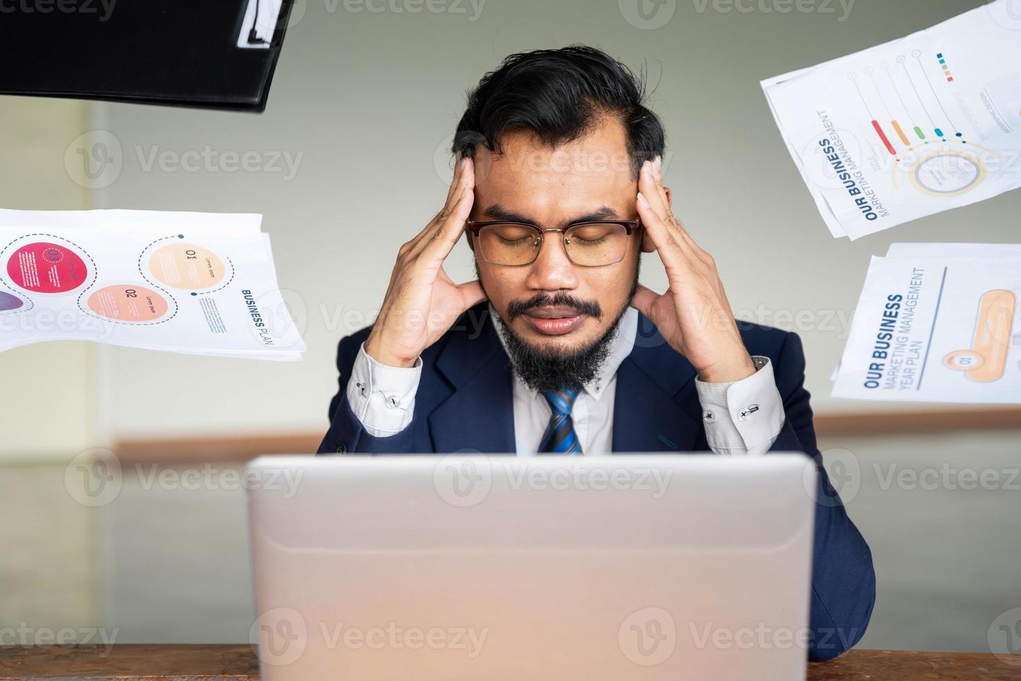 These deadlines are draining me. The image of a young businessman is anxious at his desk in the office. photo