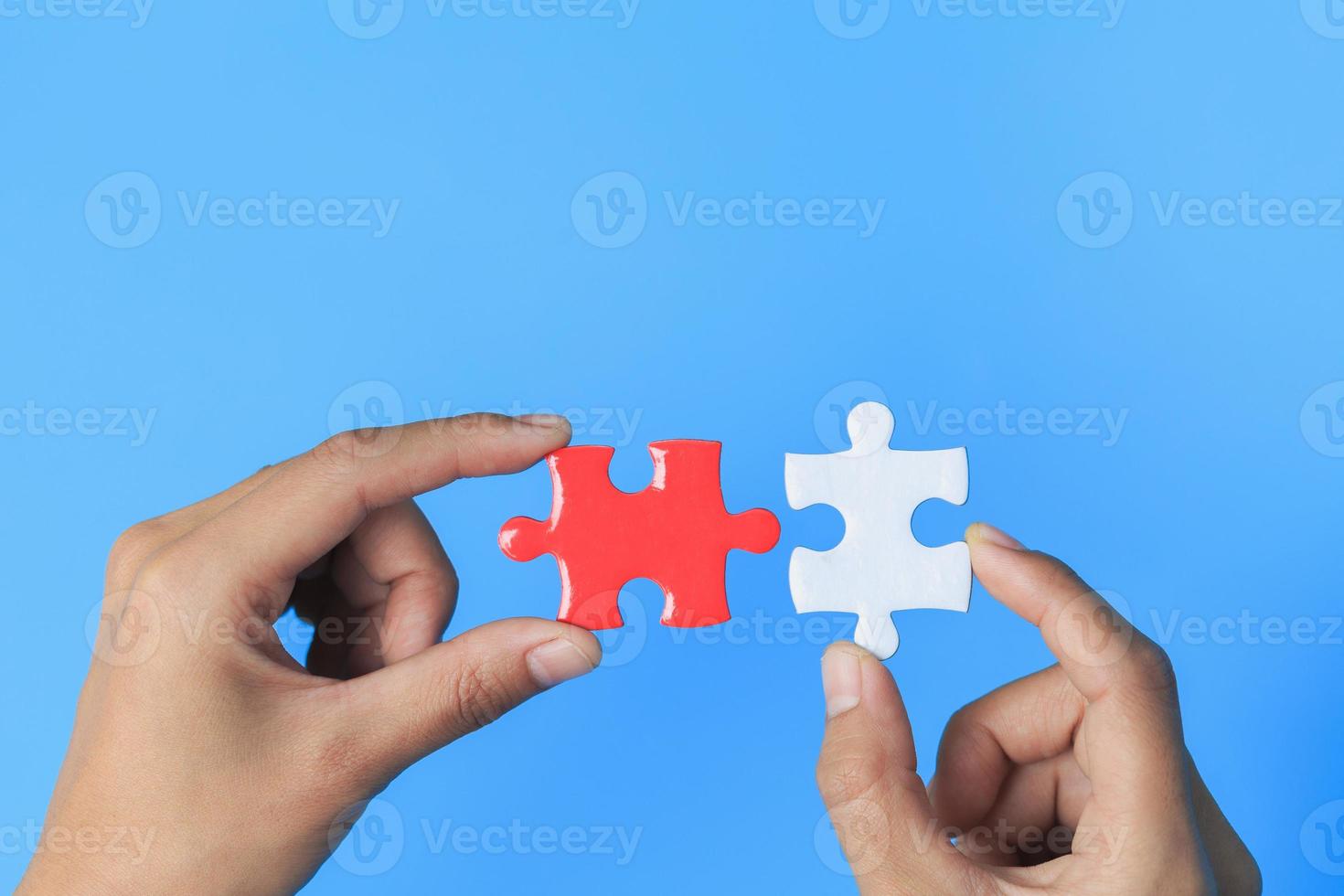 Business women connecting white and red jigsaw puzzles, , cooperation in decision making, team support in solving problems and corporate group teamwork concept. photo