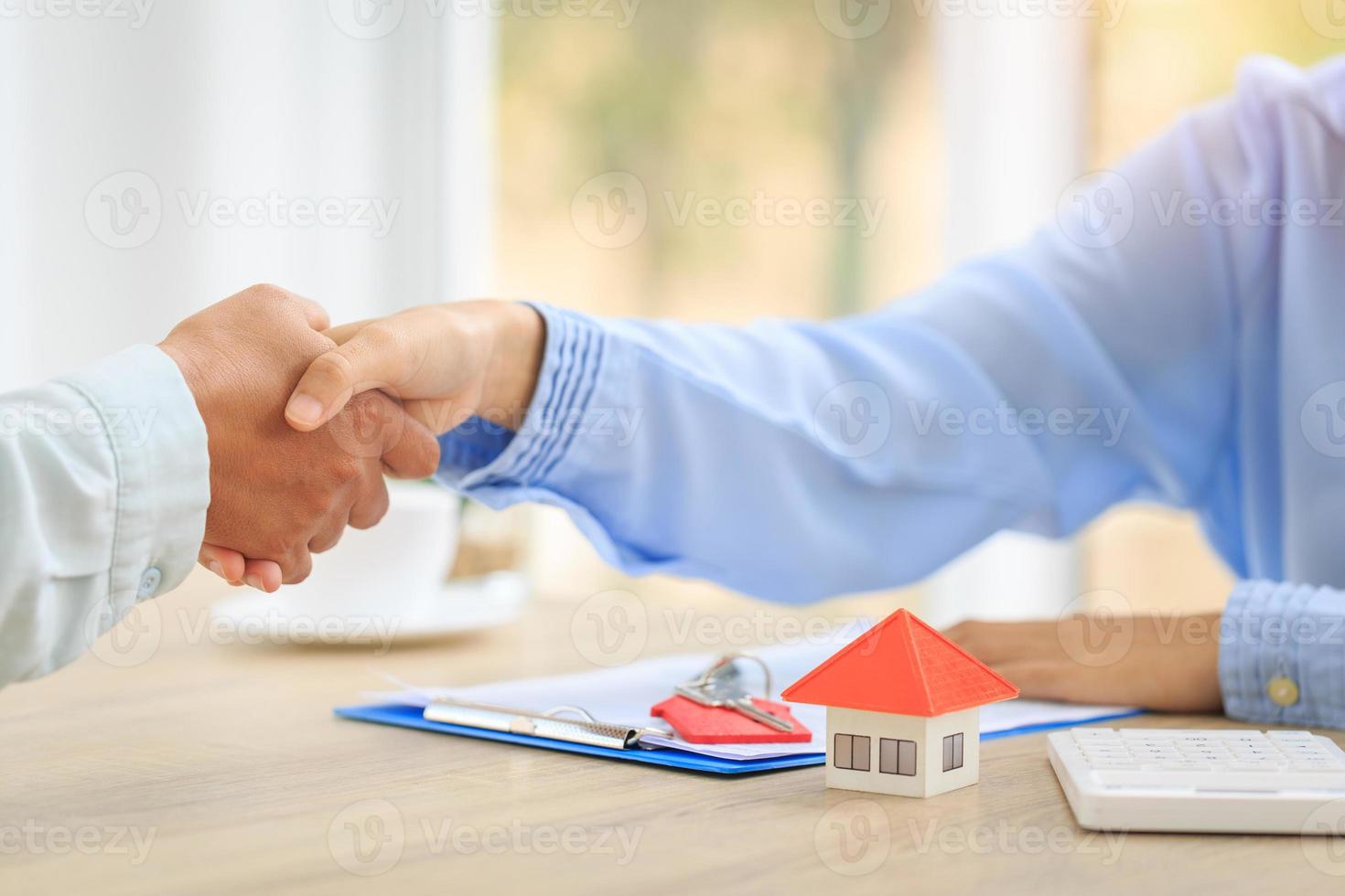 Agents and clients shake hands after signing paperwork and making a business agreement to transfer property rights. Concept of buying and selling houses. photo