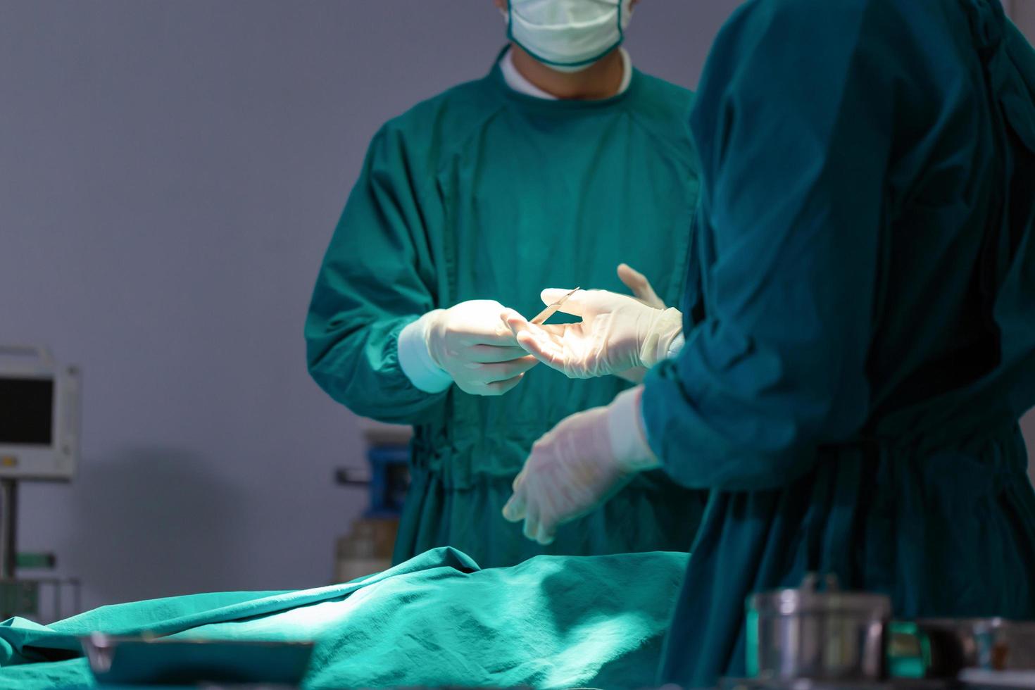 Professional medical doctors performing surgery. Assistant hands out instruments to surgeons during operations. Surgeons perform operations. photo