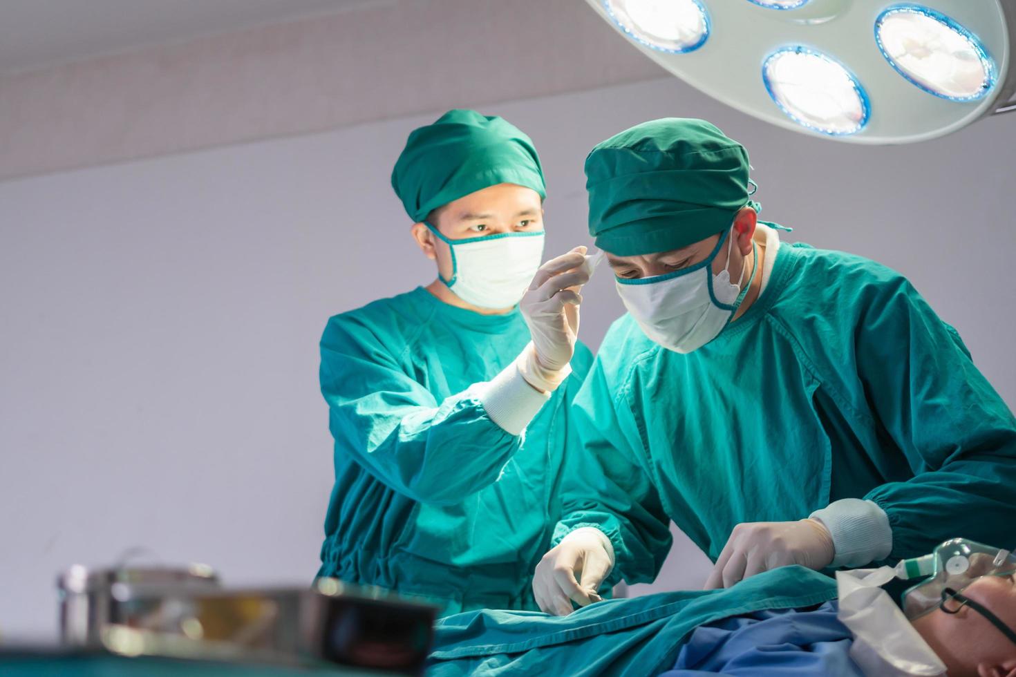 Medical team performing surgical operation in operating Room, Concentrated surgical team operating a patient photo